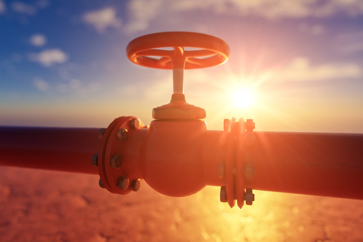 Gas pipe with red valve on sunset background