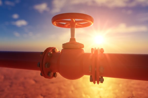 Gas pipe with red valve on sunset background